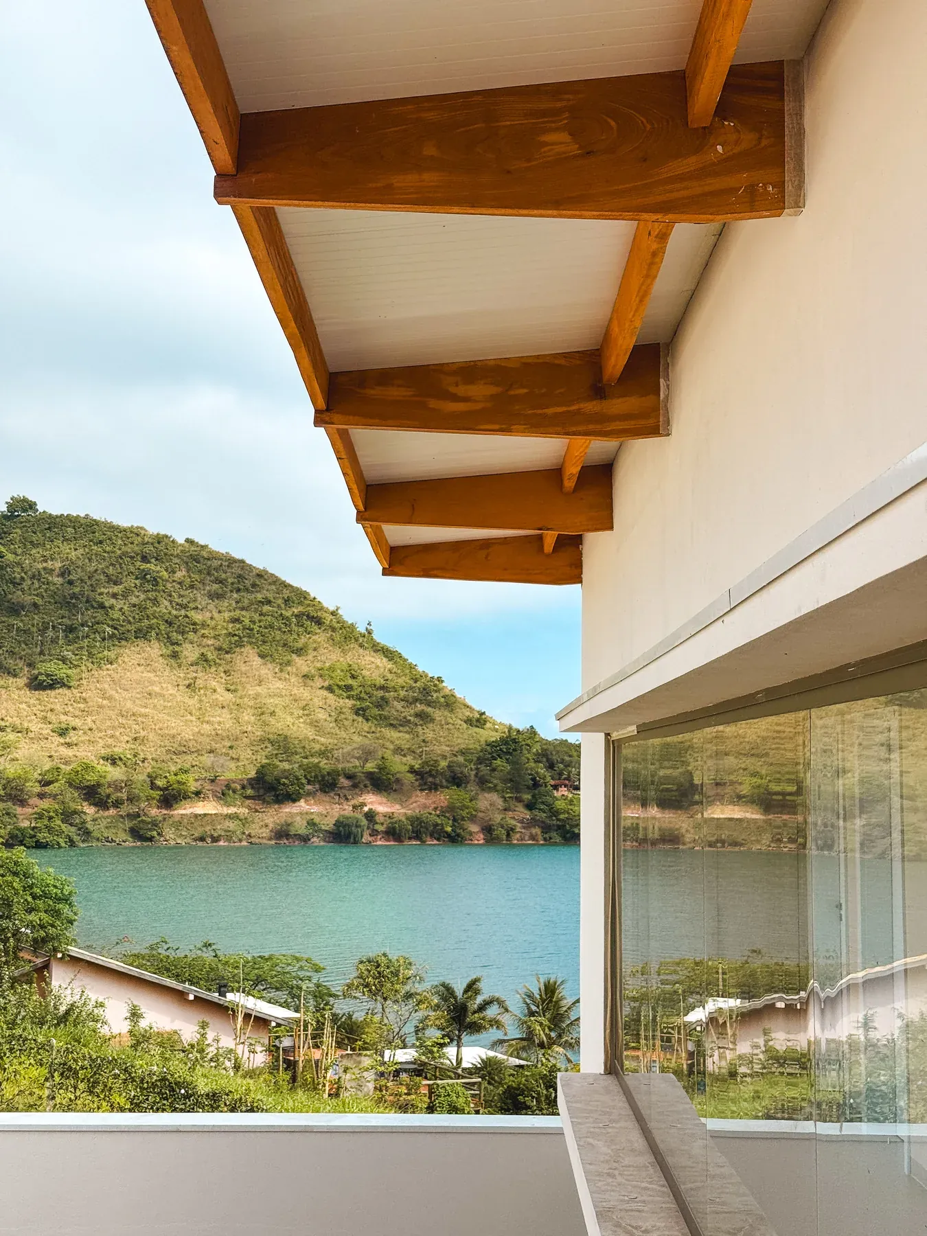 Beiral com vigas de madeira aparentes, com vista para o lago